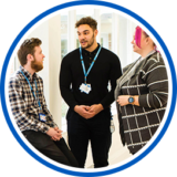 two males and one female having a conversation in a corridor