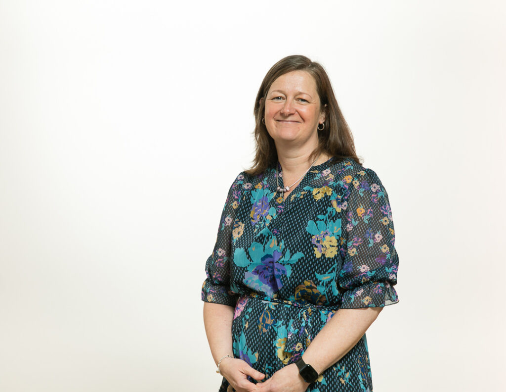 Sara Munro smiling in a floral dress