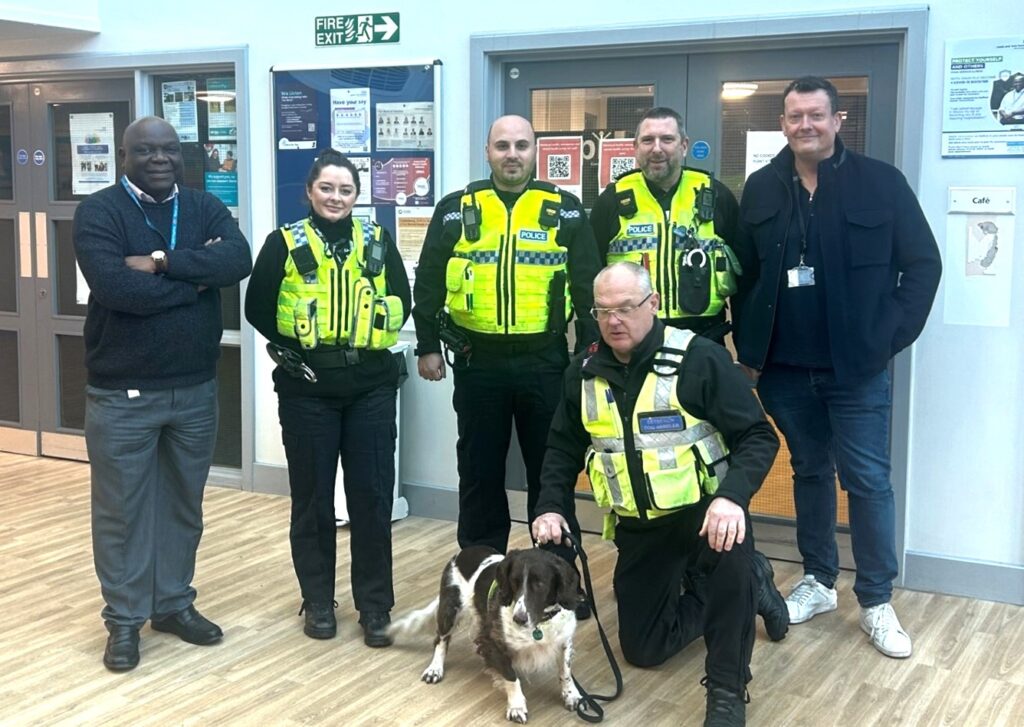 Jethro the drug detection dog with NHS staff and police officers