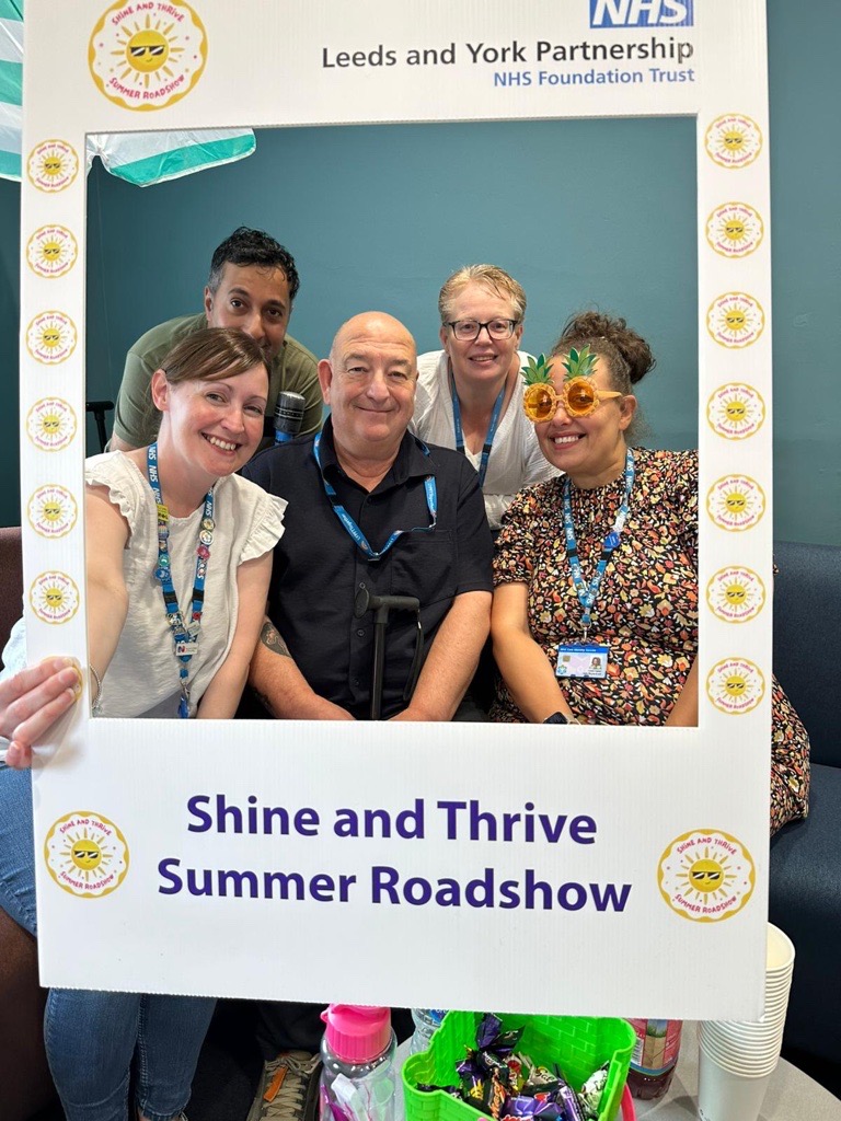 Members of our learning disabilities team inside a selfie frame at the Shine and Thrive roadshow.