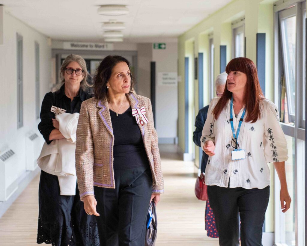Prof Malik walking down a corridor in the Becklin Centre with Trust service manager Gail Galvin.