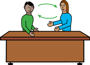 Cartoon-style illustration of two people sitting at opposite sides of a desk, facing each other. Green arrows between them show that they are having a conversation or exchanging information.